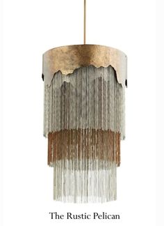 a chandelier hanging from the ceiling with gold and silver fringes on it