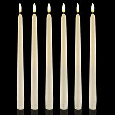 five candles are lined up against a black background