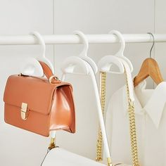 two purses are hanging on the clothes rack