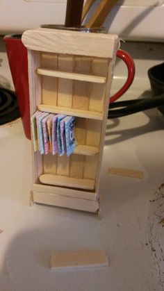 a miniature wooden book shelf on top of a stove