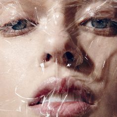 a woman's face is covered with plastic wrap around her eyes and nose, as if it were wrapped in plastic