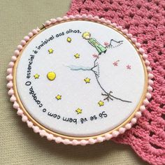 a pink crocheted doily with a white embroidered design on it and a quote