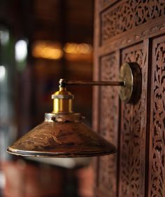 an antique light hanging from the side of a wooden door