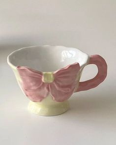 a pink and white cup with a bow on it