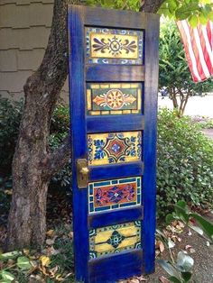 an old door is painted blue and has colorful tiles on the bottom half of it