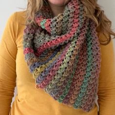 a woman wearing a multicolored crocheted scarf