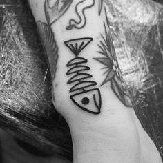 a black and white photo of a person's arm with a fish tattoo on it