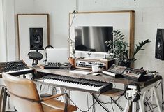 a desk with musical equipment on it in front of a tv and sound equipment set up