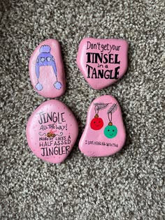 three pink rocks with words on them sitting on the ground in front of carpeted area