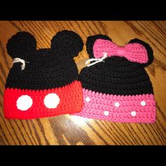 two crocheted minnie mouse hats on top of a wooden table next to each other