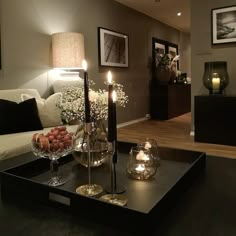 a living room filled with furniture and candles on top of a coffee table in front of a couch