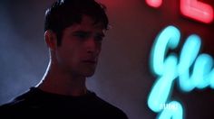 a man standing in front of a neon sign