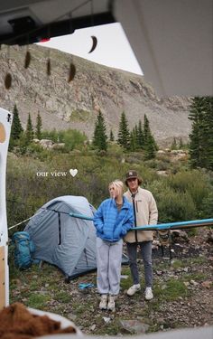 two people standing in front of a tent