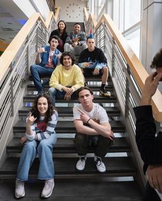 a group of young people sitting on top of stairs