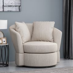 a living room with a chair, lamp and pictures on the wall