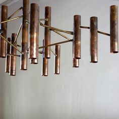 a chandelier made out of metal tubes hanging from the ceiling in a room