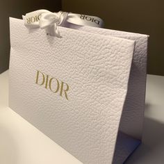 a white bag with the word dior on it and a bow tied around the front