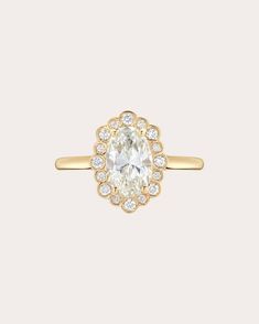 an oval cut diamond ring with diamonds on the band and center stone set in 18k yellow gold