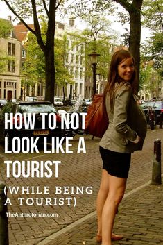 a woman standing on the sidewalk with her legs crossed and text overlaying how to not look like a tourist while being a tourist