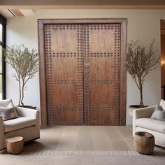 a living room with two couches and a large wooden door in the middle of it