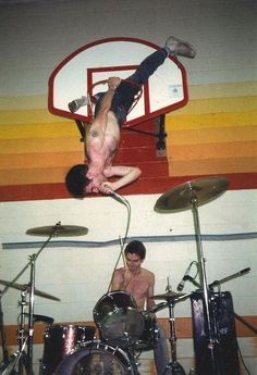 a man is upside down while playing drums