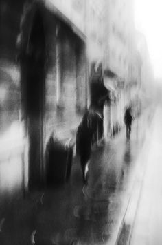 black and white photograph of people walking down the street