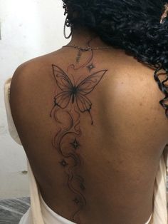 a woman with a butterfly tattoo on her back