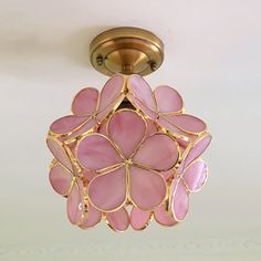 a pink flower shaped light fixture hanging from the ceiling