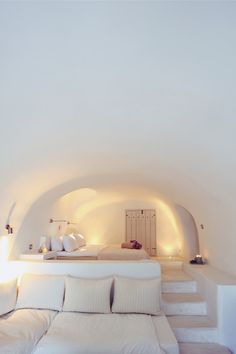 a white couch sitting in the middle of a living room next to a wall with lights on it