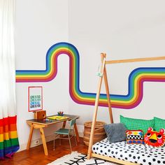 a child's room with a rainbow painted on the wall and wooden bed frame