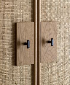 a wooden cabinet with two black handles on the front and back doors, made out of natural wood