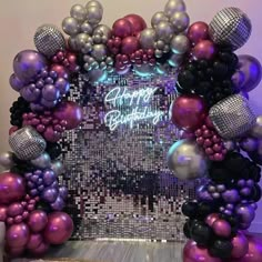 a purple and silver birthday party decoration with balloons, streamers and confetti