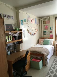 a bedroom with a bed, desk and shelves on the wall next to a window