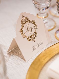 a table with place cards and wine glasses