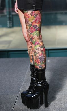 a woman's legs with tattoos and high heels