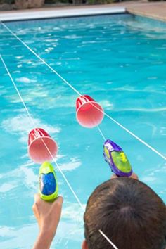 a boy is playing with water toys in the pool