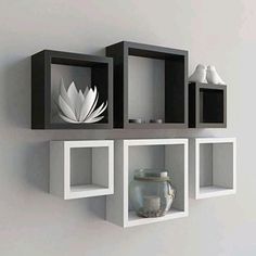 some shelves with vases and other items on top of them in a white room