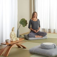 a woman sitting in a lotus position on the floor