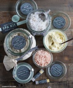 several jars filled with different types of body scrubs on top of a wooden table