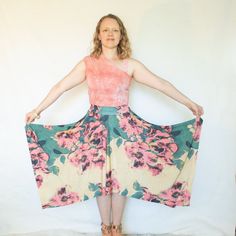 a woman is standing with her hands on her hips and wearing a floral print skirt