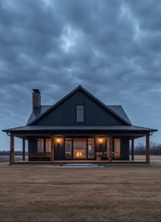 a large black house sitting on top of a grass covered field