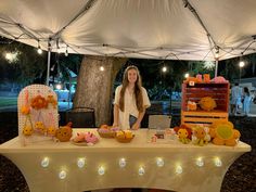 a woman standing next to a table with stuffed animals on it