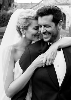 a bride and groom embracing each other in black and white