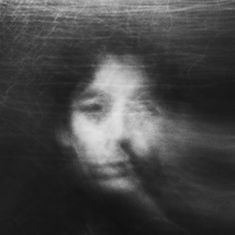 a blurry image of a woman's face in black and white