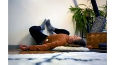 a woman laying on the floor with her legs crossed and feet up in the air