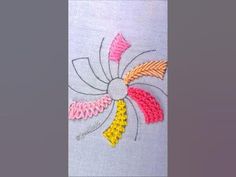 a close up of a piece of embroidery on a white cloth with yellow, pink and orange flowers