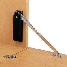 a wooden desk with a pair of scissors on it and a door hinge attached to the wall