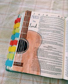 an open book with a guitar on top of it and the words against the lead