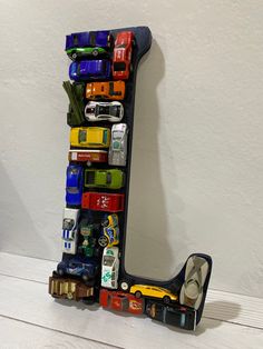 the letter j is made out of toy cars and other things on it's side