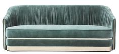 an upholstered green velvet sofa with pleated fabric on the arms and back